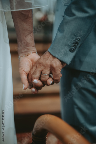 Mariés se tenant la main pendant la cérémonie de mariage à l'église