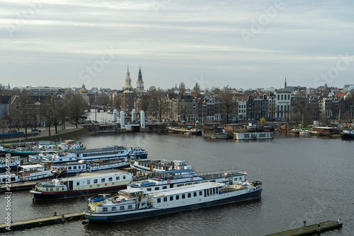 Panoramic view of Amsterdam city skyline, Amstel river and houseboats in Netherlands