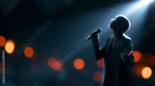 Faceless pop artist performing live on stage, illuminated by a single dramatic spotlight, epic cinematic performance capturing passion and energy, dark background creating a