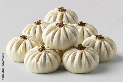 Fresh bao buns stacked on a plain surface