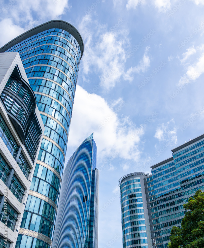 Fototapeta premium Dynamic composition of curved glass office towers and contemporary skyscrapers rising above Brussels financial district beneath a bright sky with generous copy space for design
