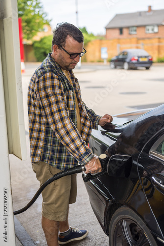 Corby, Northamptonshire, UK - August 2, 2026: Man driver refueling black car at gas station