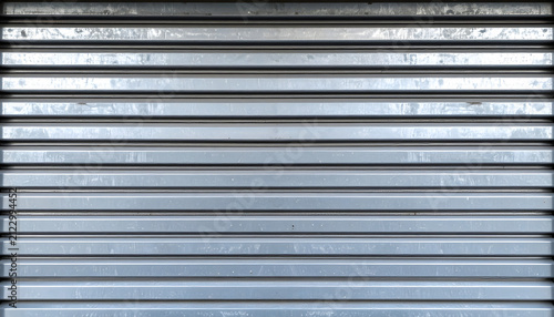 Metal shutter door background featuring horizontal grey industrial panels with a weathered metallic texture and clean symmetrical parallel line patterns
