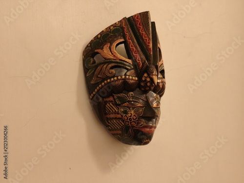 Angled view of a hand carved Indonesian wall mask