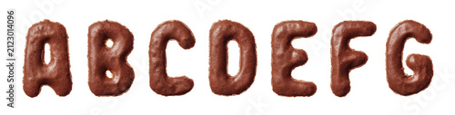 First seven letters of the alphabet A to G shaped as chocolate glazed cookies lined up horizontally on a pure white background