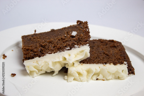 two slices of plum cake on a large plate against a white background