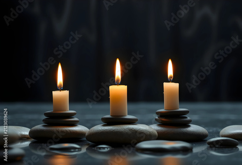 Three lit candles on stacke...