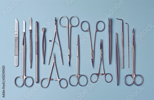 Stainless Steel Surgical Instruments Arranged on Clean Blue Medical Background