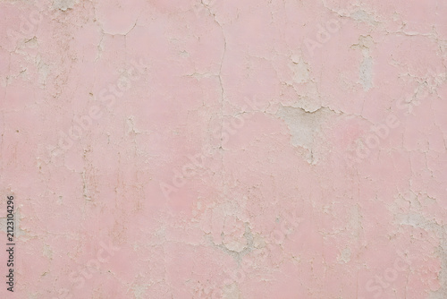 Vintage distressed pink plaster wall texture. Old crumbled stone surface with peeling paint. Shabby chic background.