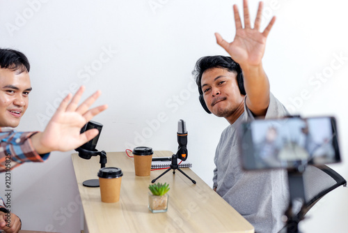 Fotografía Two Podcast Hosts at Camera While Recording Live episode with Microphones and Sm