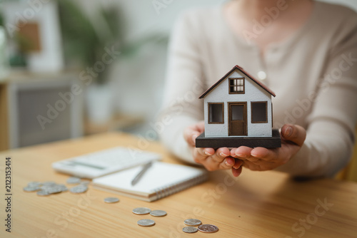 home ownership, house model, and property savings shape this practical household finance scene. It conveys practical choices, organized planning, everyday money management, and financial awareness.