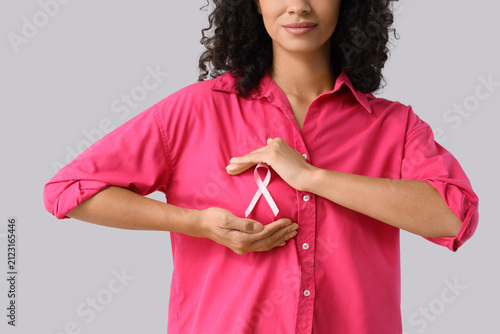 Young woman with pink ribbo...