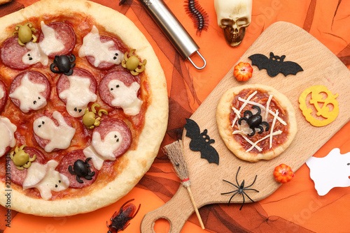 Canvastavla Composition with tasty pizzas and Halloween decorations on orange background