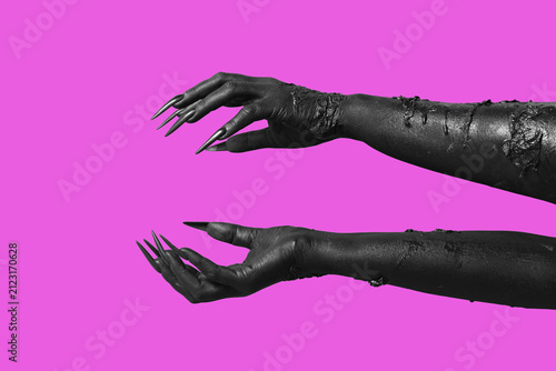 Black hands of witch on pur...
