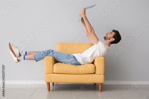 Young man with laptop sitti...