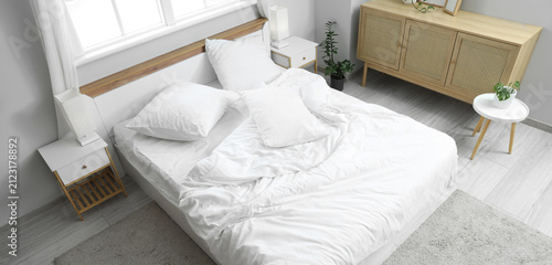Unmade bed with white sheet...
