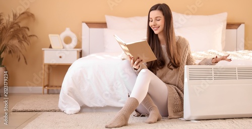 Smiling young woman reading...