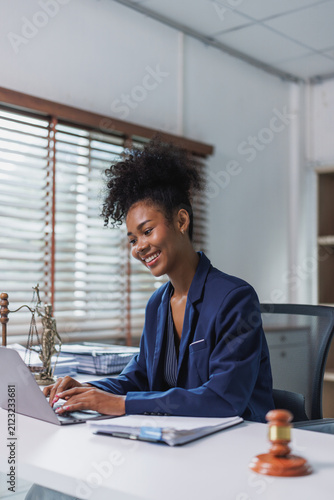 Smiling lawyer working on laptop in modern office