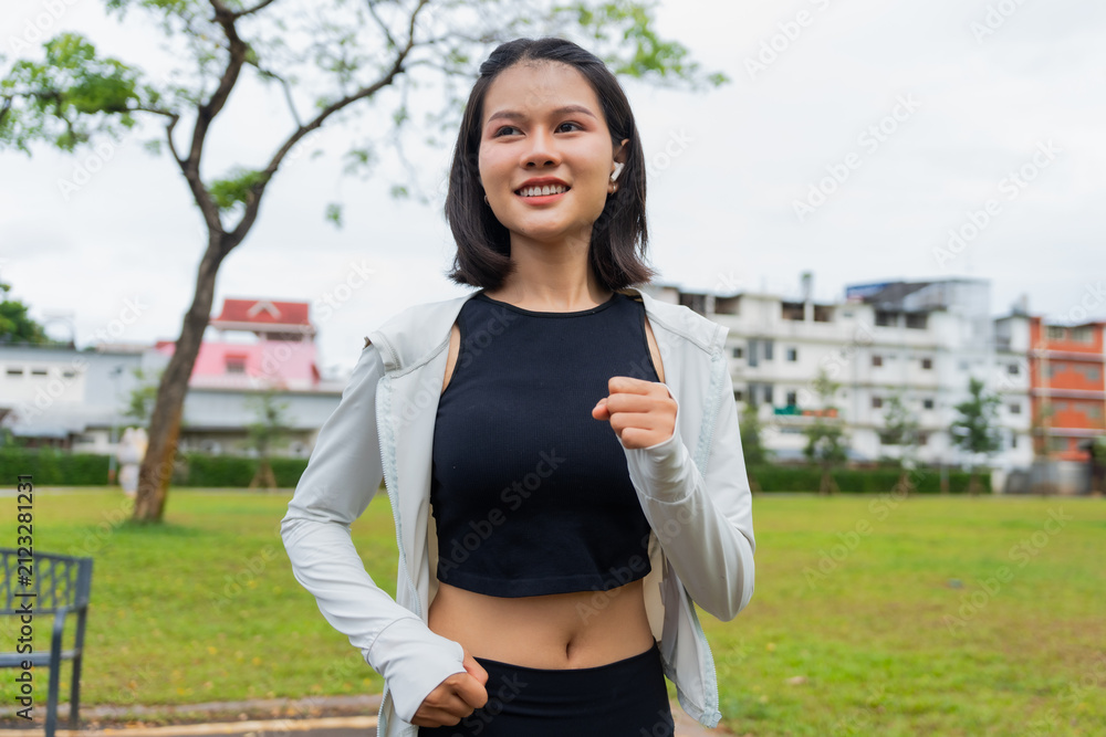 Fototapeta premium Asian sporty woman running in public park