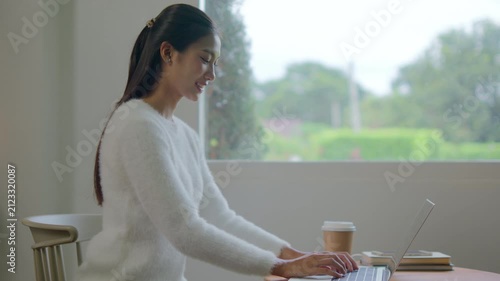 Woman works remotely from living room using laptop comfortably