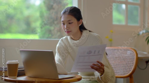 Woman concentrates on laptop work sitting at desk in living room