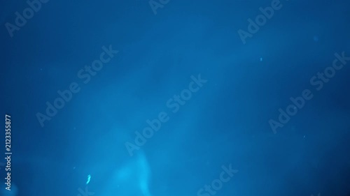 Deep blue abstract background with subtle light rays and soft bokeh creates an atmospheric or underwater concept. This tranquil and serene backdrop offers ample copy space for design, graphic, or
