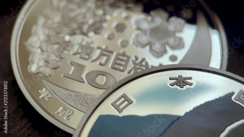 Macro video of a Japanese 1000 yen silver proof commemorative coin from Yamagata Prefecture, featuring a colorized scenic landscape, cherry motif, engraved lettering, and polished metallic surface.