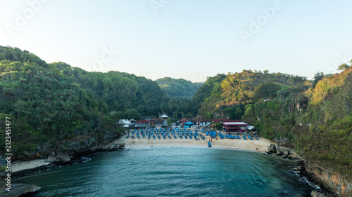 Elevated coastal view reveals a calm turquoise lagoon enclosed by lush cliffs along the secluded Ngerenean shoreline.
