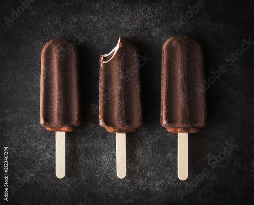 Overhead of three chocolate ice cream bars one with a bite