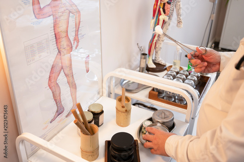 Quadro su tela At the acupuncture clinic, a white-coated practitioner holds forceps with a cotton swab