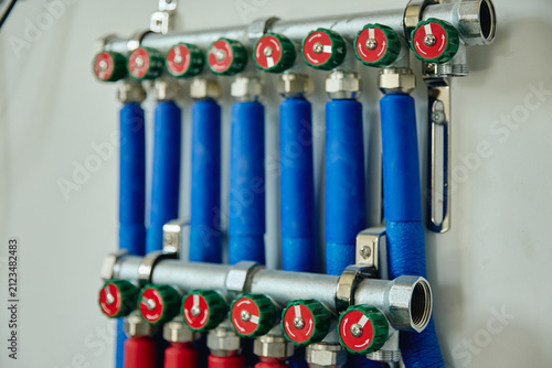 Foto Heating manifold system with red and blue pipes installed on wall during house r