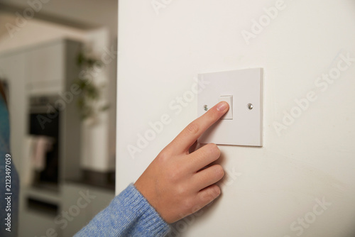 Finger of girl turning off switch at home