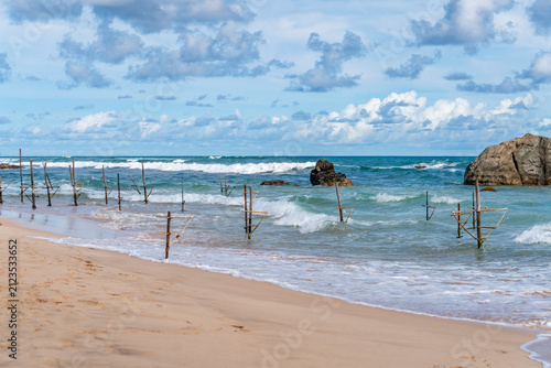Wooden stilt fishing poles in the sea at Ahangama Beach, Sri Lanka. Traditional wooden stilt fishing poles standing in the ocean at Ahangama Beach, Southern Province, Sri Lanka. 