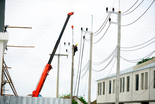 Bild auf Leinwand Worker repairing high voltage power line using crane and safety equipment outdoo