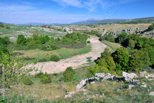 Canvas Print rugged landscape of the Nevesinje plateau with the dry riverbed of the Zalomka r