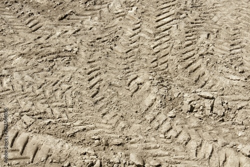 Muddy dirt with heavy machinery tire tracks