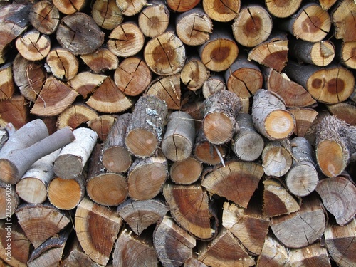 Stacked logs forming a rustic woodpile background texture