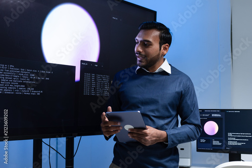 Indian male Software Engineer, Developer working with Team, Looking at Monitoring, Presenting coding, data, AI Machine Learning Model to Colleague, Discussion, Reviewing and Brainstorming together.