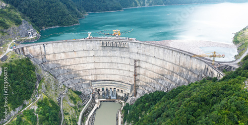 Fotografie Enguri dam aerial view of spillway basin and curved concrete structure for water management, hydroelectric engineering, flood control and infrastructure