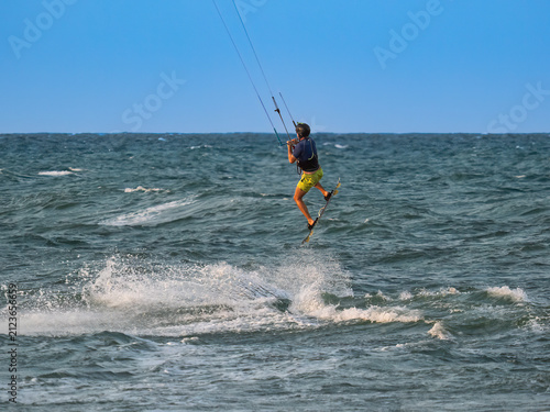 Kai, a surfer, soaring through the air on Cullera beach (Valencia, Spain)