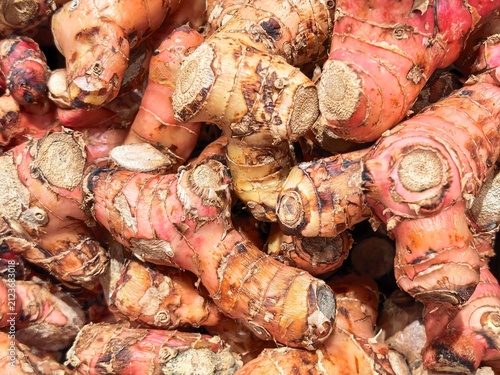 Photography Detailed close-up of pink hued turmeric roots piled together
