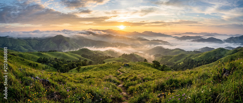 Golden sunrise over the spectacular Vagamon hills illuminating lush green meadows and mist-covered Western Ghats mountains in Kerala India