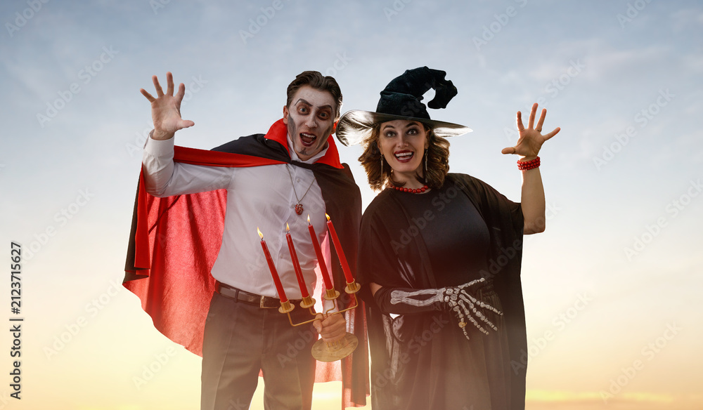 Obraz premium Happy Couple in Halloween Costumes Celebrating Outdoors at Sunset