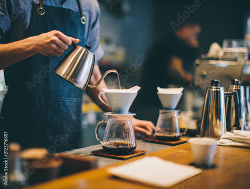 Barista preparing pour over coffee with a dripper, showcasing specialty coffee brewing and cafe culture