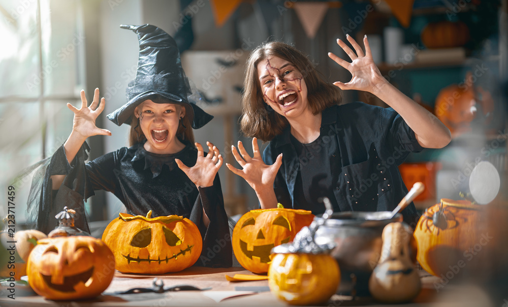 Obraz premium Happy Kids in Costumes Celebrating Halloween with Pumpkin Carving