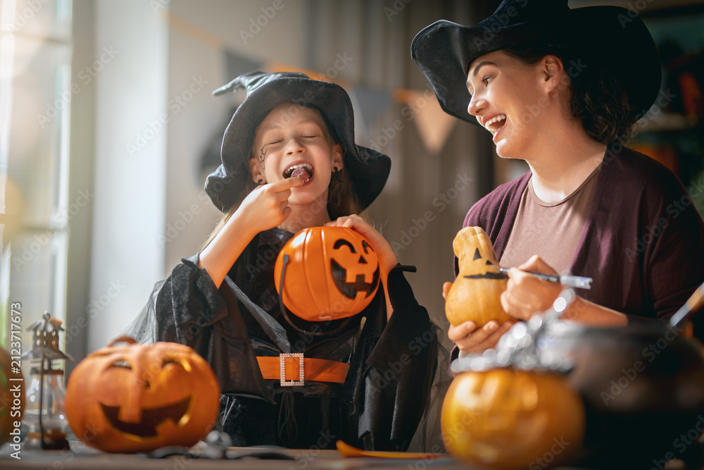Obraz premium Happy Family Enjoying Halloween Pumpkin Carving and Candy