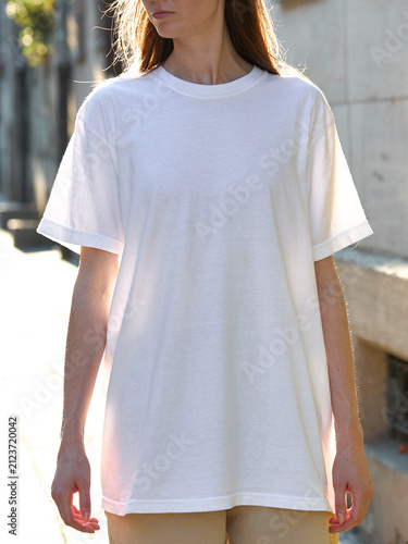 Woman wearing a plain white t-shirt and tan pants outdoors