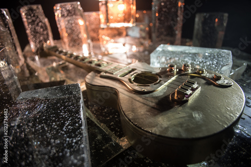 Music Concept: Guitar Miniature on a Dark Background with Vivid Light, Smoke, and Fire Effects. Golden electro guitar under a Dramatic Spotlight.