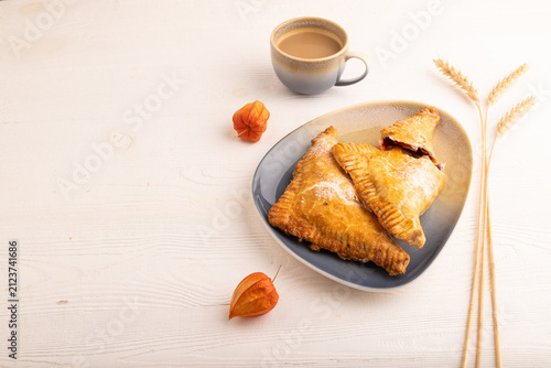 Triangles Pie, Puff Pastry, Samsa with cherry jam on white wooden, side view, copy space