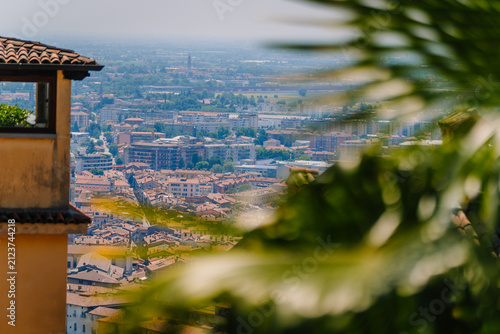 Obraz na plátně Scenic view of Bergamo cityscape with terracotta rooftops and lush greenery in t